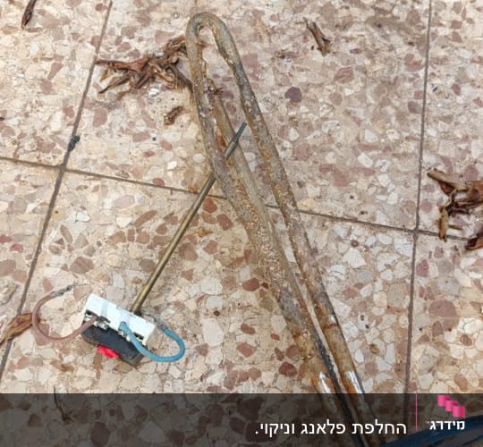 גוף חימום ישן ומלוכלך על רצפה מרוצפת